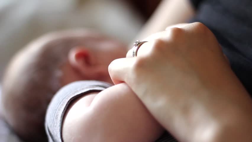 A beautiful newborn baby breastfeeding