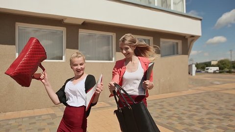 Two beautiful and happy girls are students at the University notes. Front view.