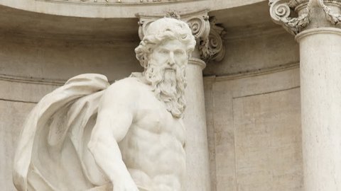 close tilt up shot of a statue of oceanus at trevi fountain in rome, italy