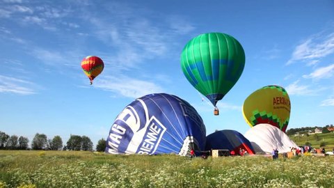MOSCOW - JUN 11: Balloons fly up in sky with passengers over green field, club of aeronautics Aeronaut, on Jun 11, 2011 in Moscow, Russia