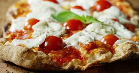 high quality pizza typical Italian food with Italian mozzarella cheese and fresh tomato sauce freshly harvested, with a fragrant basil leaf.Concept of: italian food, italy, restaurant pizza tradition.
