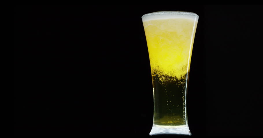 A good quality fresh beer is served in a glass cup on a black background. The beer is of premium quality and has an excellent flavor thanks to its hops.Concept of beer, high-quality and drinks. Royalty-Free Stock Footage #22034617