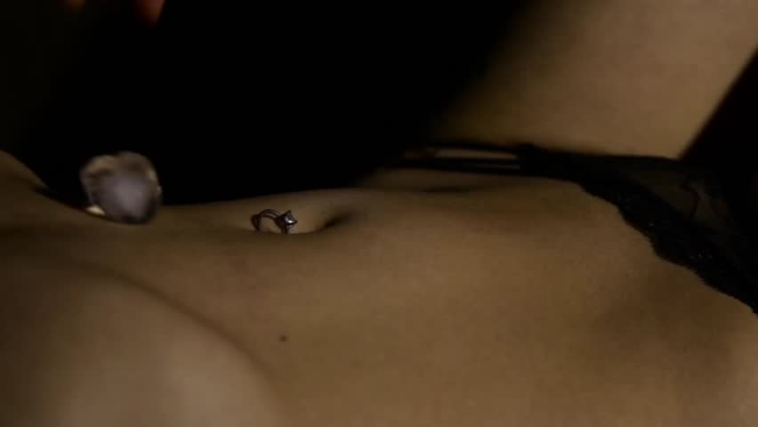 Seductive young woman in lacy panties holding ice cube in her nevel. slow motion