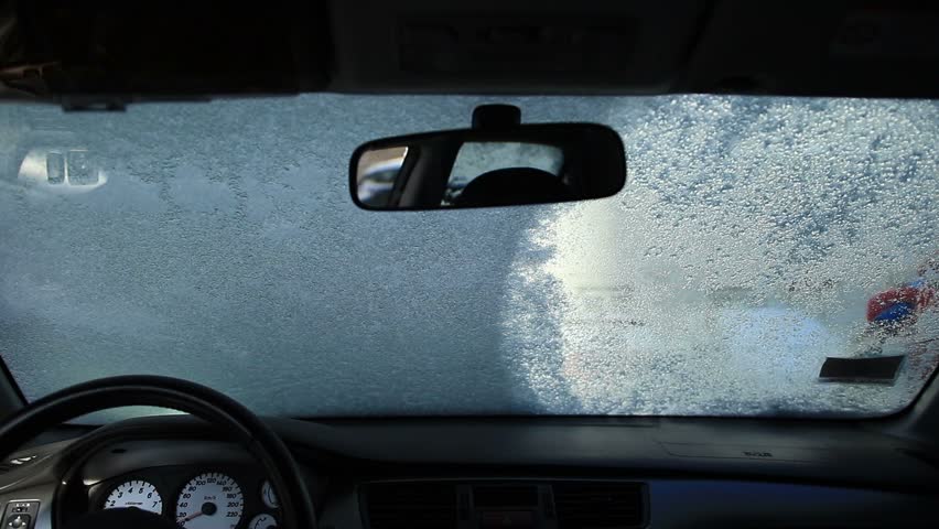 Cleaning car window with an ice scraper