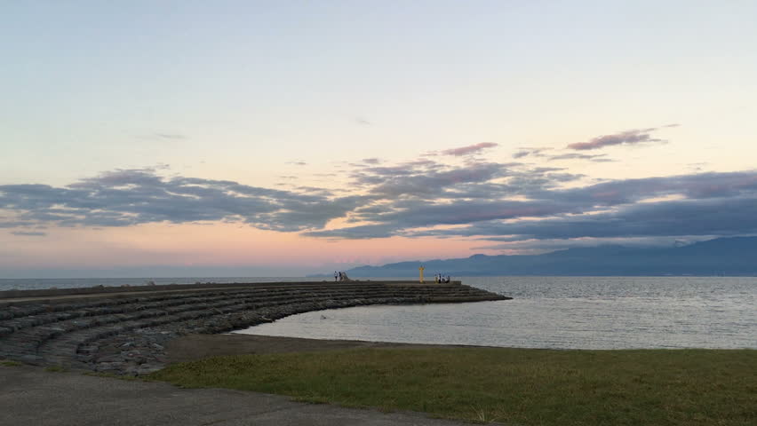 beautiful sky in dusk and people walking in the coast