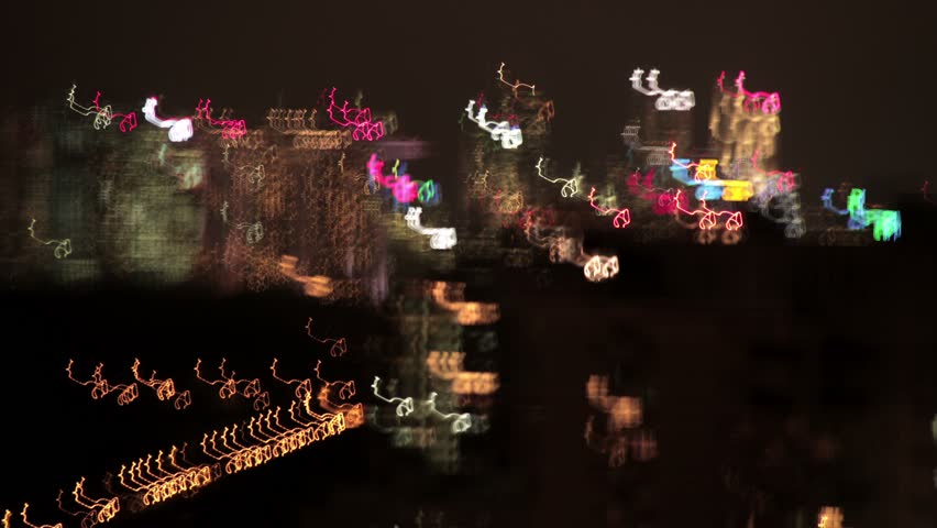 Abstract streaks of light with vague skyline, slow shutter time-lapse.