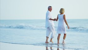 Happy senior mature Caucasian couple leisure travel enjoyment fun healthcare Summer vacation walking beach  - Powered by Shutterstock - Get 15% off with code: PIKWIZARD15