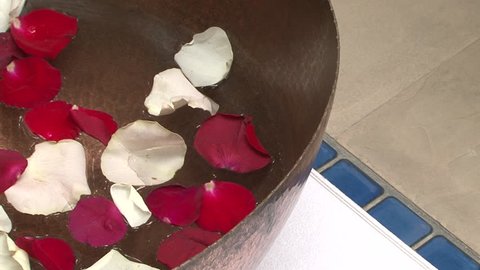 Rose petals. Pan-left on red and white rose petals floating in a brass bowl in a spa. (Dubai, UAE-2013)