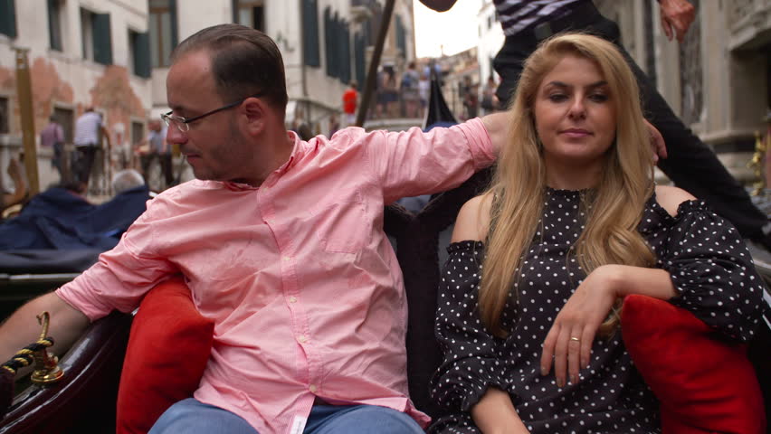Beautiful lovers couple taking pictures in Venice on Gondola ride. Romance shot in boat. Happy together on travel vacation holiday in Venice, Italy