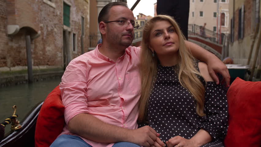Beautiful lovers couple in Venice on Gondola ride. Romance shot in boat. Happy together on travel vacation holiday in Venice, Italy