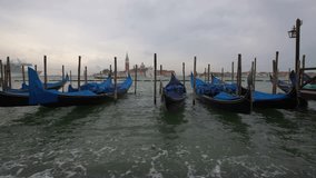 Gondolas in San Marco, Venice, Italy. Gondolas boats at sunset. Traditional italian gondolas boats docked at San Marco, sunset background in Venice, Italy. View to San Giorgio Maggiore venice, Italy