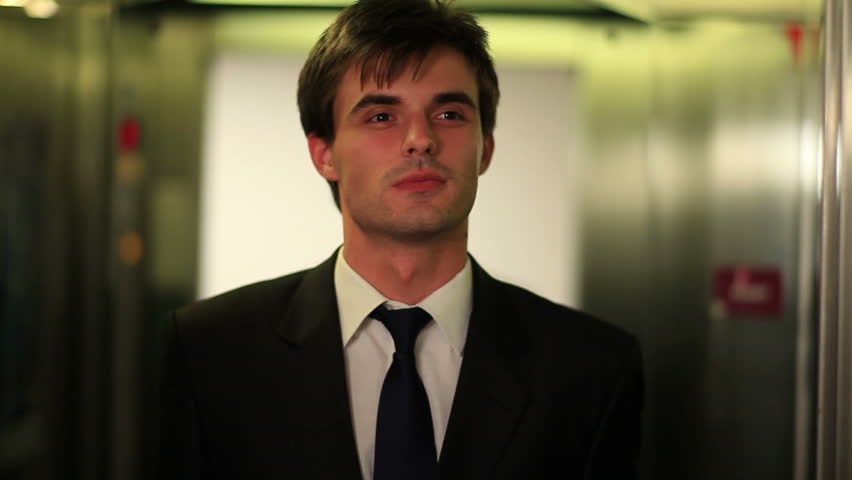 Young businessman entering an elevator