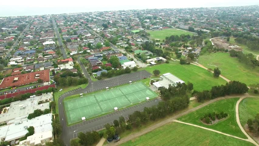 Slow descend near netball courts in a park with urban area in the background. Bicentennial park, Chelsea, Melbourne, Australia