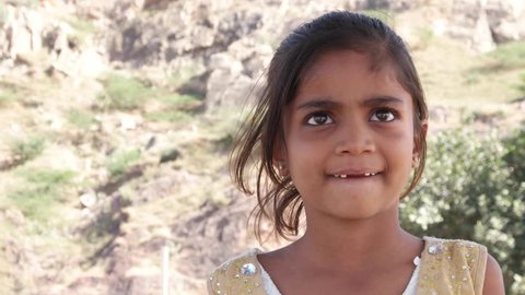 Portrait of an Indian girl with missing teeth and looking at someone off camera 