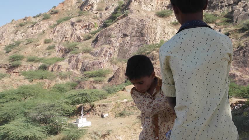 Portrait of an Indian girl scared and covering her face with her hands with missing teeth 