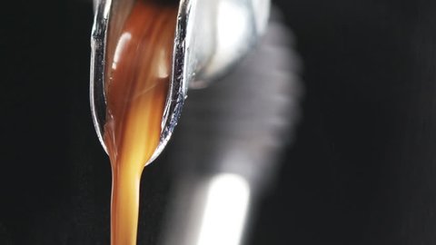 macro shot of coffee extraction and pour from professional coffee machine over black background, 180fps prores footage