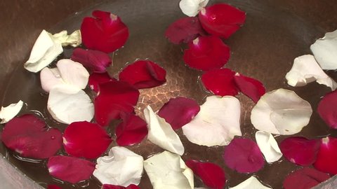 Rose petals. Pan-right on red and white rose petals floating in a brass bowl in a spa. (Dubai, UAE-2013)