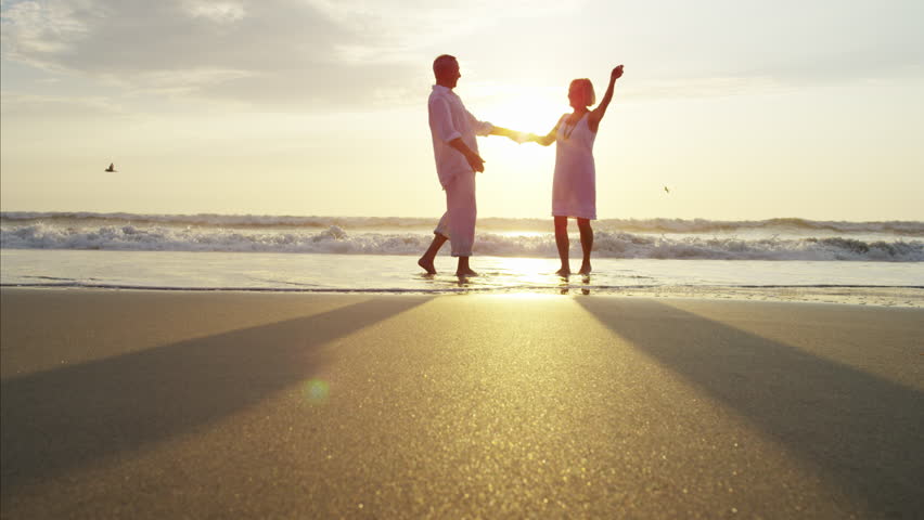 Silhouette mature seniors Caucasian couple dancing lifestyle healthcare enjoyment savings ocean beach sunset dusk RED DRAGON | Shutterstock HD Video #22096387