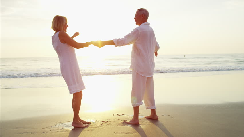 Retired Caucasian couple bright clothing leisure dance health care romance memories beach flare sunrise RED DRAGON | Shutterstock HD Video #22096441