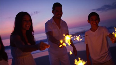 Silhouette Spanish family parents kids leisure together sparklers party fun ocean beach sunset dusk RED DRAGON