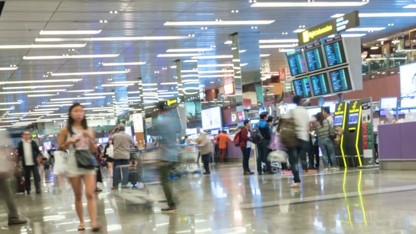 SINGAPORE - FEB 23, 2016 : 4K Timelapse blur background of many passenger walking in front of check-in counter at Changi International Airport, Singapore