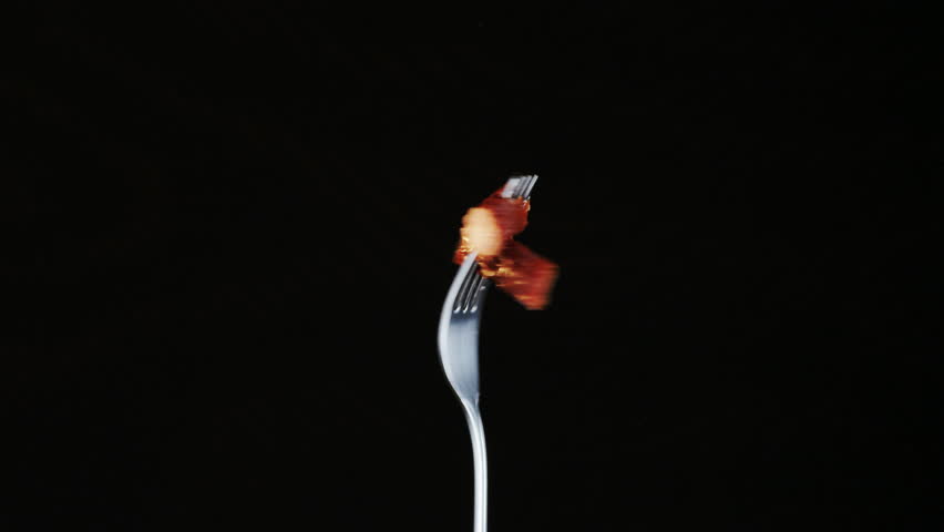 Rotating Fork With Two Dry Pork Sausages on Black Background