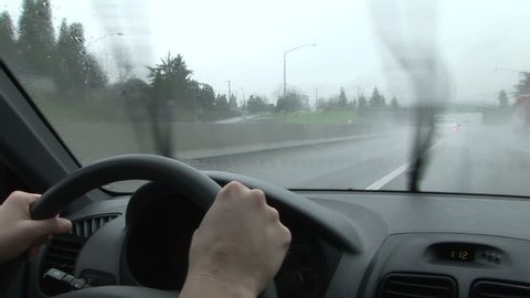 Woman driving car through the rain on highway, windshield wipers working, Portland, Oregon Format: NTSC HDV Compression: MotionJPEG-A Camera: Sony HVR-Z1U Size: 1080i (1920 x 1080) Sound: No