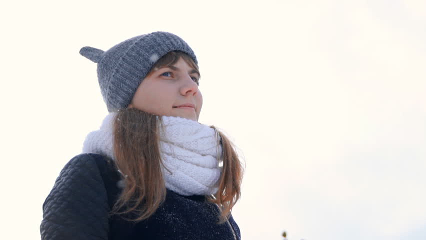 charming winter lady blowing a handful of snow right in the camera