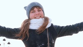 charming winter lady blowing a handful of snow right in the camera