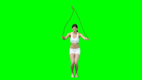 Young woman skipping against a green screen