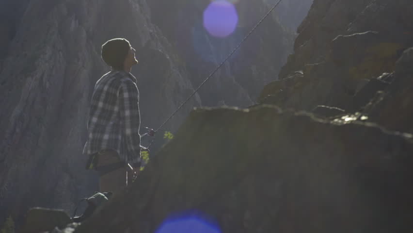 Man Belays His Climbing Partner On A Beautiful Sunny Day In Utah Mountains
