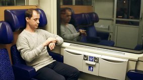 Man using his smartwatch in a train. Modern wearable device technology. 4K video