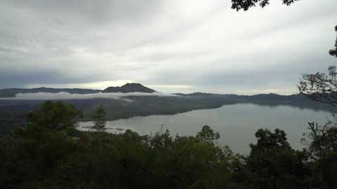 Mount Batur volcano and lake Batur in cloudy day. Located at the center of two concentric calderas north west of Mount Agung on the island of Bali, Indonesia.
