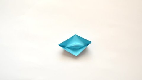 Making of blue origami paper boat. Stop motion movie.