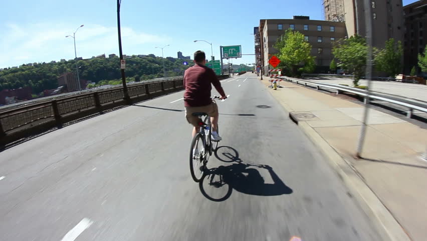A man rides his bike on a Pittsburgh street.