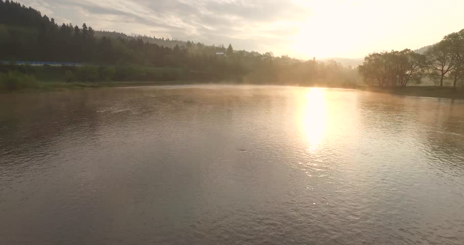 Sun is reflected in a mountain river. Sunrise aerial view