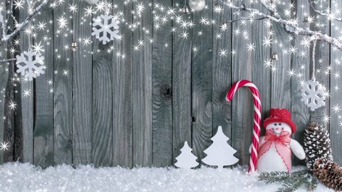 Christmas interior with decorative branches, snowman and candy cane on wooden planks background. 