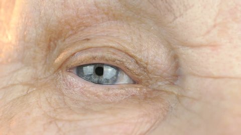 Close-up of blue eye of a old woman aged 80s