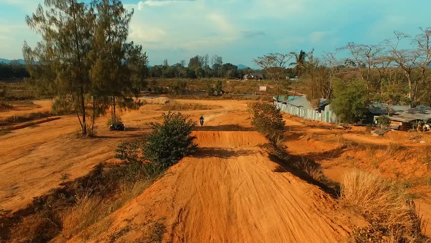 Aerial: Jump on motocross track. Slow motion.