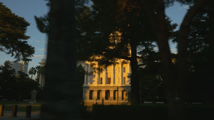 Tracking shot of the California capitol building in downtown Sacramento at sunset.