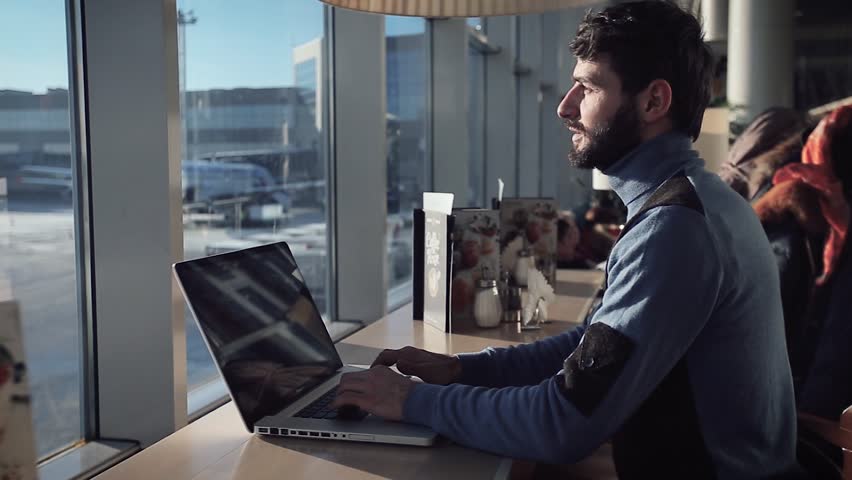  A young man  working  on laptop    sitting near the window in cafe  at the airport 
closes his laptop and go alonng  Royalty-Free Stock Footage #22158961