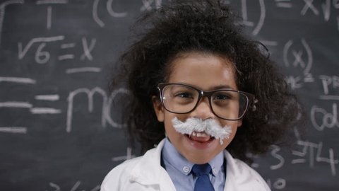 4K Happy little scientist with fake mustache writing math formulas on blackboard