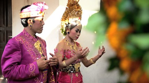 Wedding Balinese style bride and groom attending the marriage ceremony in traditional dress Indonesia South East Asia: film stockowy