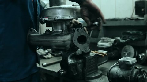 Auto mechanic repairs a turbocharger