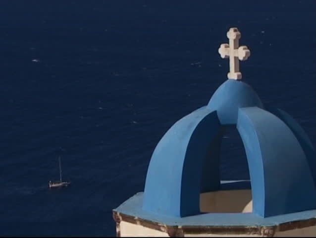 White cross on the blue dome of the church - sailing ship in the sea as background