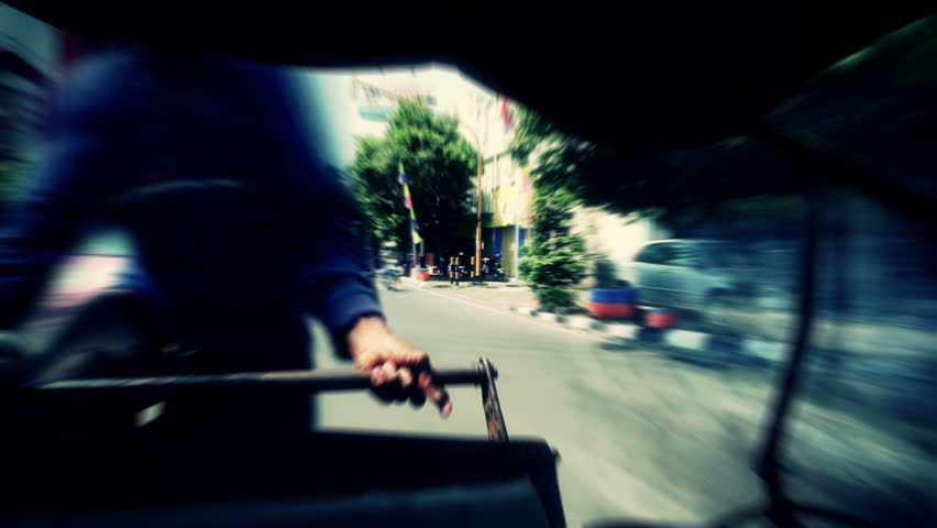 Wild ride on a bicycle rickshaw through busy asian streets on a bright shiny day