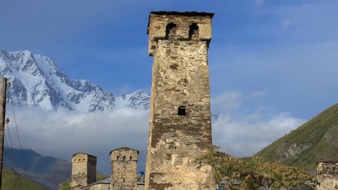 Svaneti Old village in Georgia. Medieval tower built for defensive purposes. Each family had its own tower. In the background is seen the Caucasian mountains and clouds.