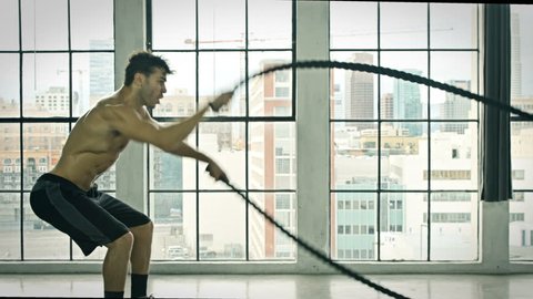 Athletic Male Working Out Using Battle Ropes. Crossfit. Slow Motion.