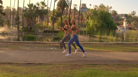 Athletic Twins Working Out. Running in a beautiful park at sunrise.