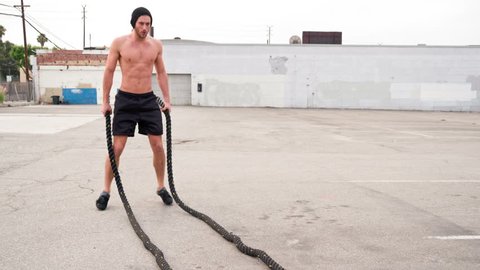 Athletic male working out in an empty parking lot. Crossfit. Slow Motion.